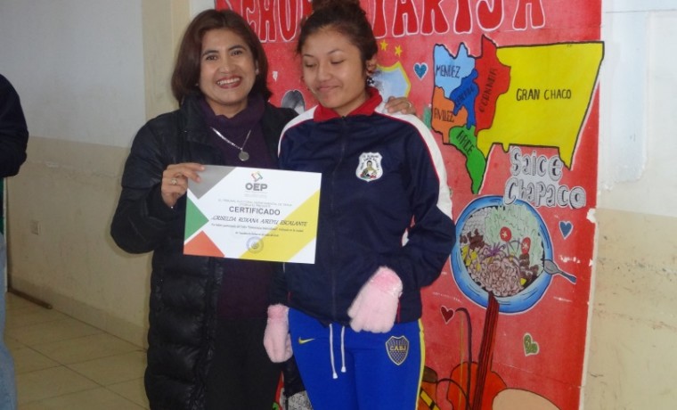 Presidenta del TED Tarija, Cristina Vargas, entrega los certificados de reconocimiento a estudiantes de la unidad educativa Simón Bolívar 4.