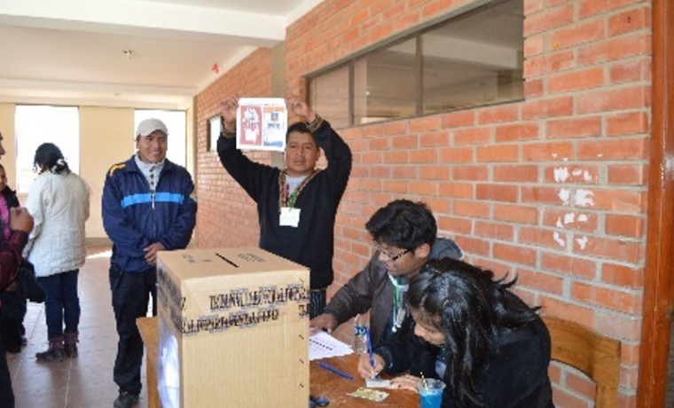 Jurado electoral muestra la papeleta de votación.